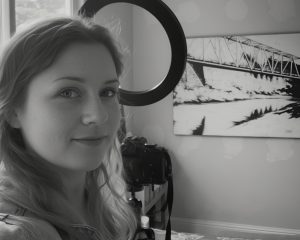 Photo of artist with large acrylic painting in black and white.